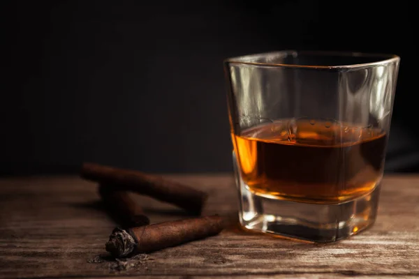 Cigarros y vasos con brandy en la mesa — Foto de Stock