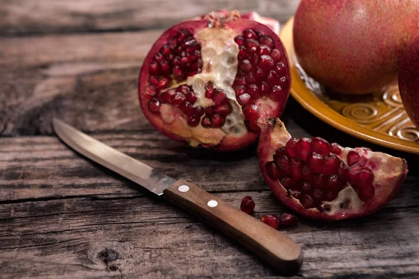 Masanın üzerinde bir bıçakla soyulmuş nar