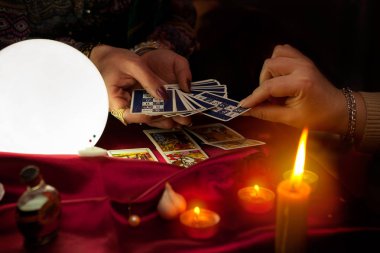 Yaşlı çingene falcının elinde Tarot kartları