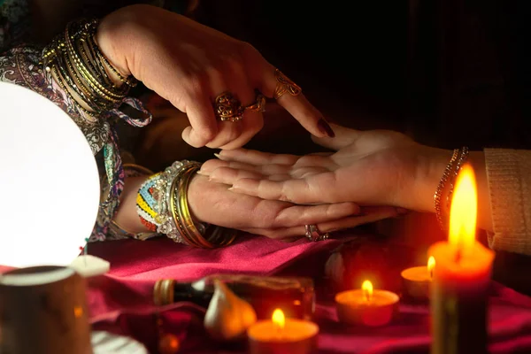 Gypsy woman reading future from another womans palm