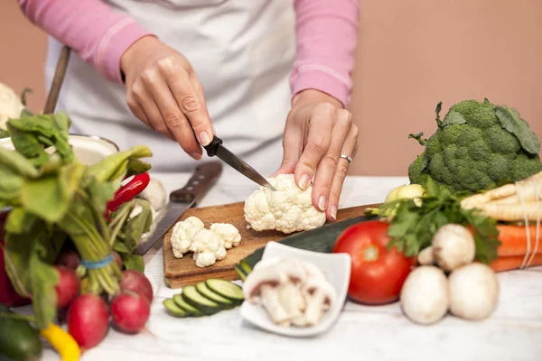 Verse bloemkool van vrouw snijden met een mes — Stockfoto