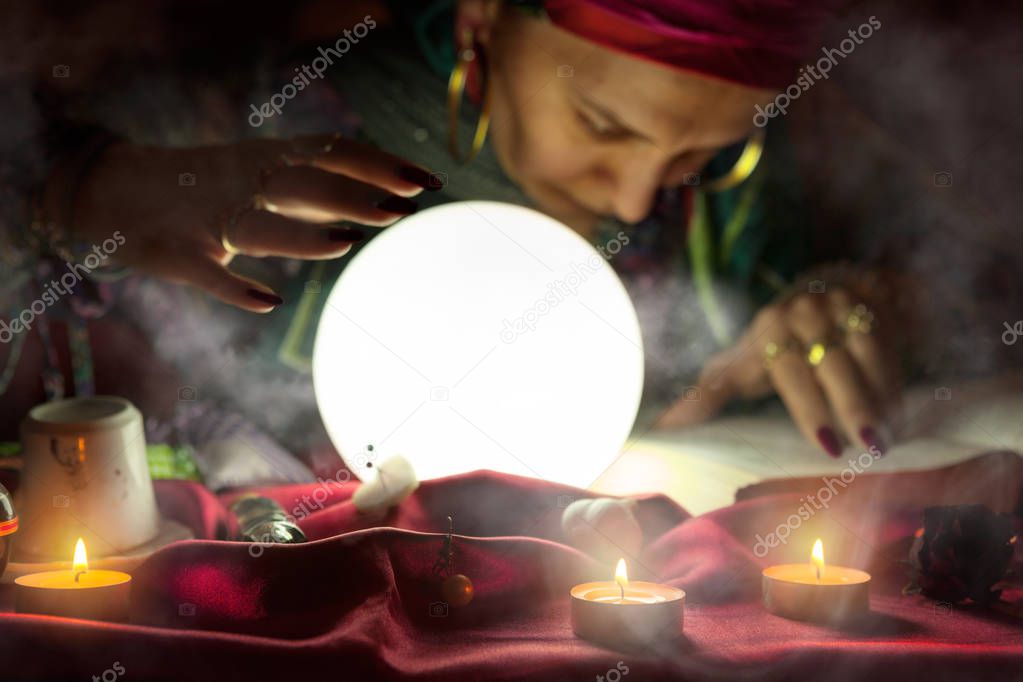 Old gypsy woman looking in the book of spells