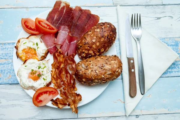 Ovanifrån på tallrik med stekt ägg, bacon, tomat och bullar, Chron — Stockfoto