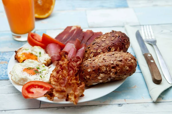 Frisch zubereitetes Frühstück mit Speck, Eiern und Brötchen — Stockfoto