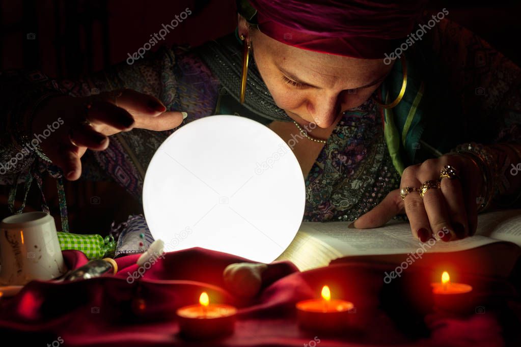 Gypsy woman read an old book of spells