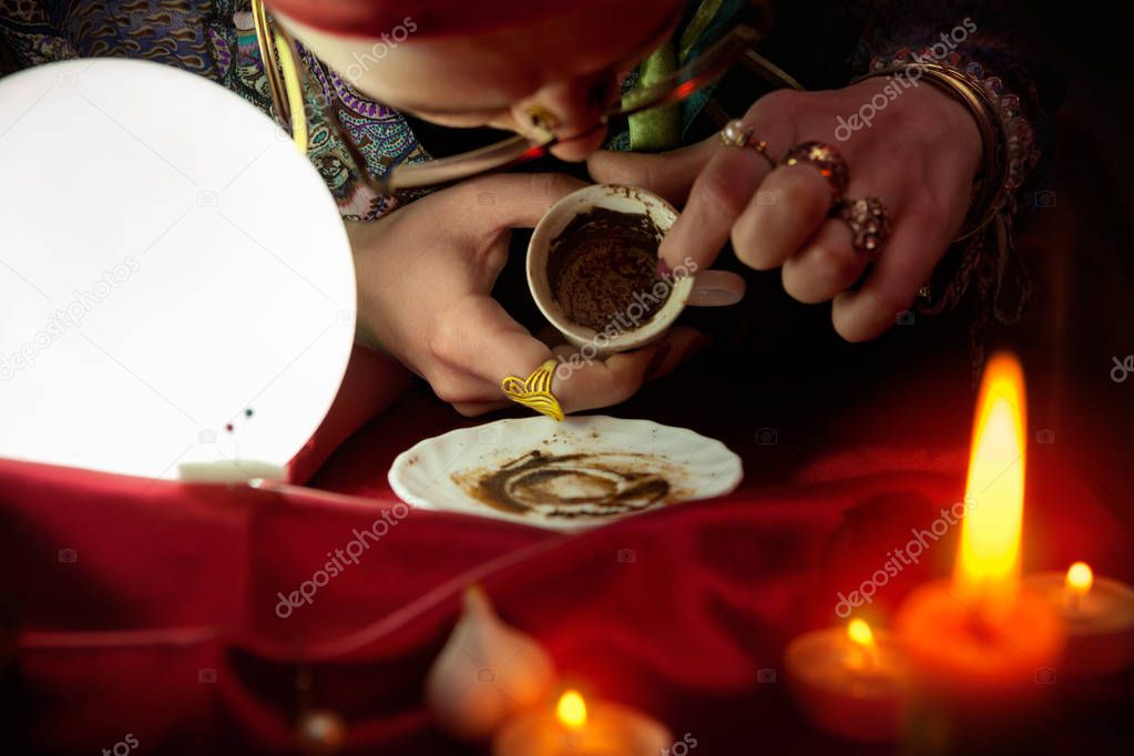 Woman fortune teller looking in empty coffee cup