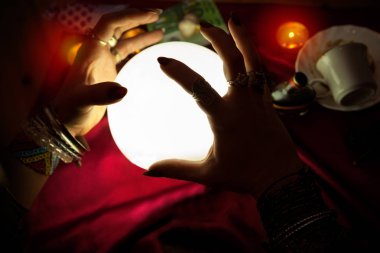 Fortune teller kadının ışıklı kristal küre üzerinde eller