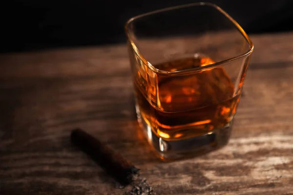 Vaso con whisky y cigarro sobre la mesa — Foto de Stock
