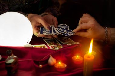 Yaşlı çingene falcının elinde Tarot kartları