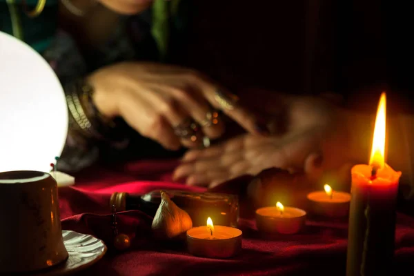 Queimando velas e mulher que lê o futuro da palma na parte de trás — Fotografia de Stock