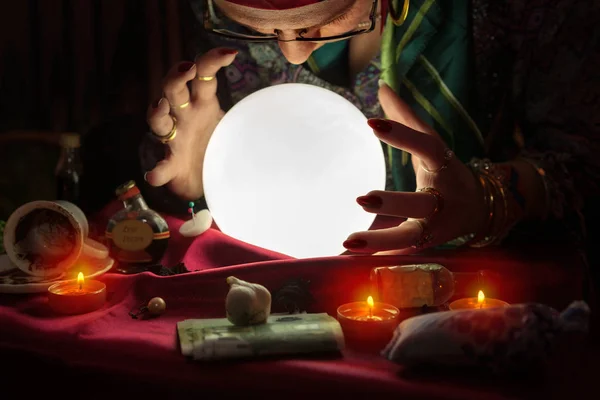 Gypsy woman looking at crystal ball and reading the future