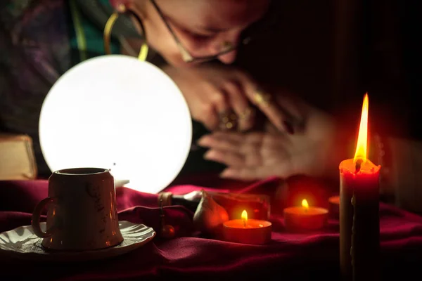 Bola de cristal brilhante e vela ardente com leitura da palma fortuna — Fotografia de Stock