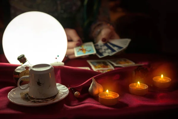 Cofee taza, velas y bola de cristal brillante con tarjeta del tarot en han — Foto de Stock