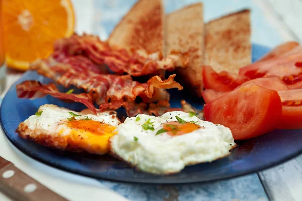 Stekta ägg och cripsy bacon-frukost på tallrik — Stockfoto