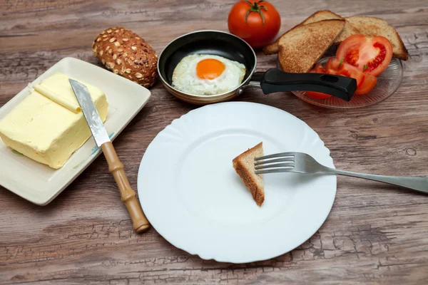 Pan, tereyağı, ekmek ve domates-kahvaltı masasında yumurta