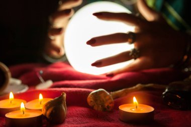 Kristal kürenin önündeki falcı cadının elleri.