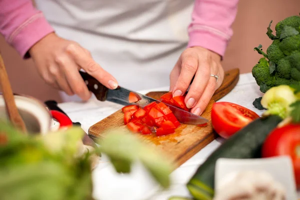 Woman cutting tomato on slices — Stock Photo, Image