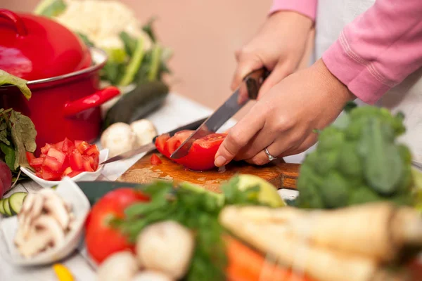 Frau schneidet Tomaten in der Küche — Stockfoto