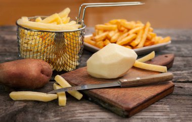 Doğrama kurulu üzerinde bir bıçak ile patates 