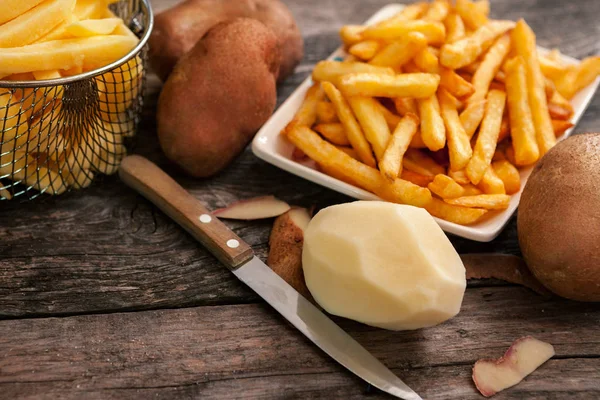 Peeled potato, knife and french fries — Stock Photo, Image