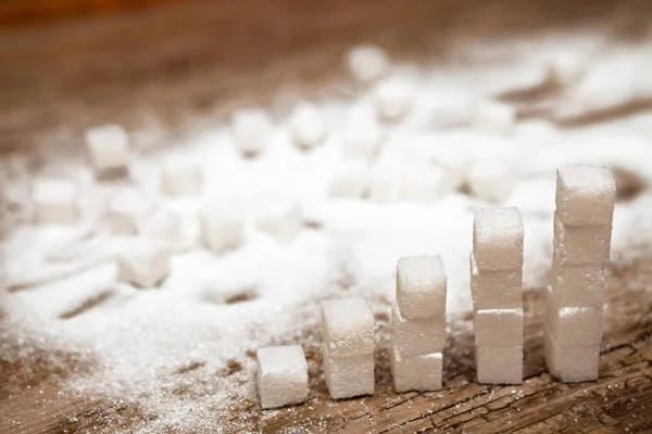 Sugar cubes and sugar pile on wooden background, diabetes and hi