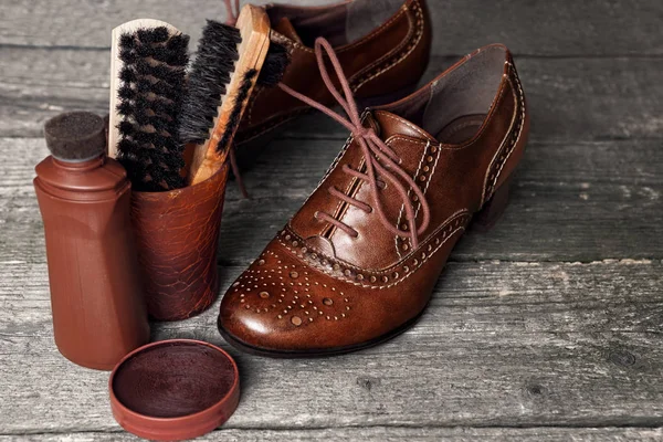 Ayakkabı parlatıcısı ve fırçalar ahşap yüzey üzerinde