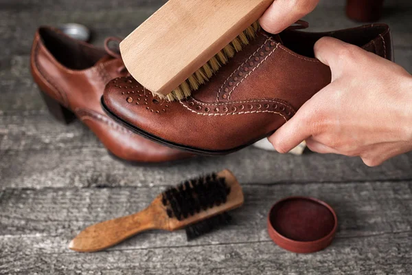 Worker cleaning elegant shoe with brush — Stock Photo, Image