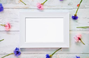 Beyaz bir çerçeve mockup masaya çiçek ile