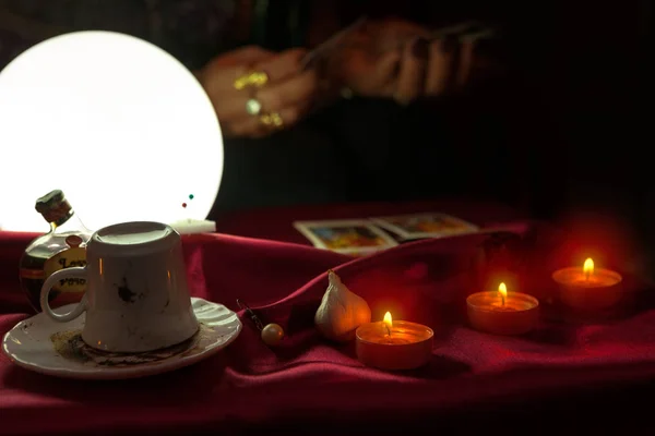 Taza de café, velas y bola de cristal brillante con tarjeta del tarot en ha — Foto de Stock