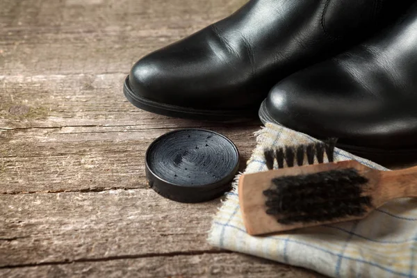 Crema polaca, botas negras, pincel y tela — Foto de Stock