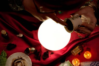 Çingene falcı fal baktırmak için elinde kahve fincanı tutuyor.