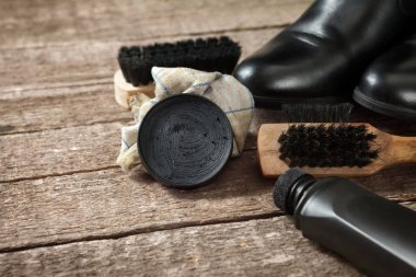 Lehçe krem, fırça, kumaş ve siyah çizmeler