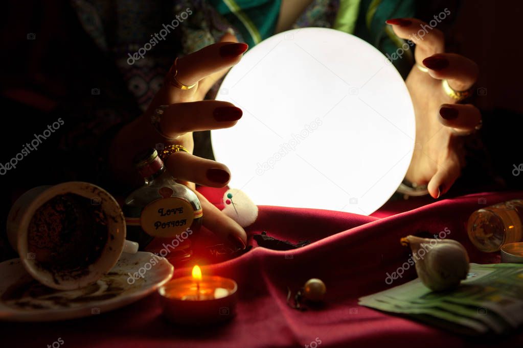 Gypsy woman put her hands around crystal ball