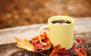 Güz ahşap masa üzerinde sıcak çay bardağı