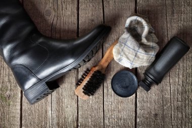 Ekipman parlatma ile masada siyah çizmeler