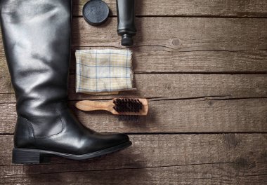 Lehçe krem, siyah çizme, fırça ve kirli bez