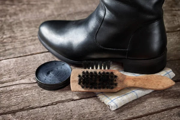 Чорний черевик на тканині з дерев'яною щіткою — стокове фото