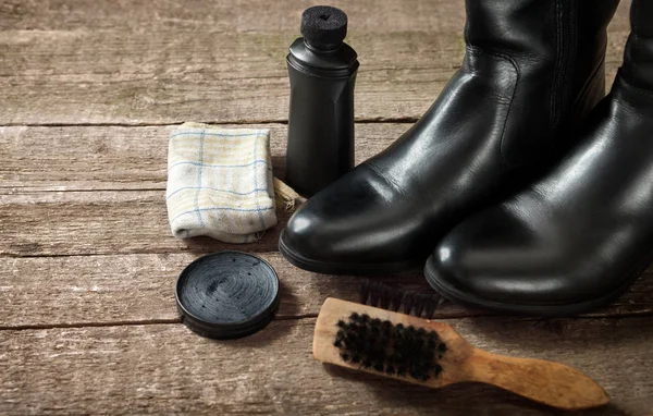 Botas negras, crema de esmalte, pincel y tela — Foto de Stock