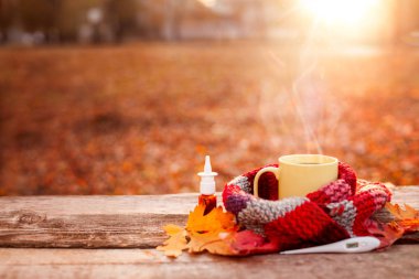 W üzerinde sıcak eşarp, termometre ve burun damla çay kupa kaplı