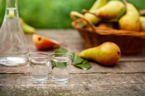 Pear brandy in shot glass.Pears in background. — Stock Photo, Image