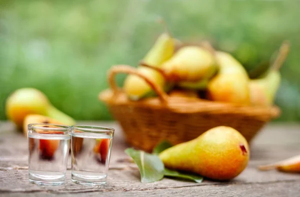 Päron konjak i snapsglas. Päron i bakgrunden. — Stockfoto