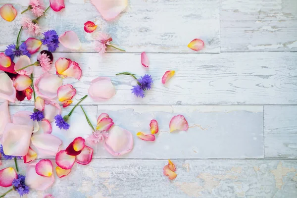 Flores y pétalos sobre mesa de madera —  Fotos de Stock