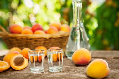 İçki kadehi ile ahşap masa üzerinde olgun kayısı kayısı brandy içki