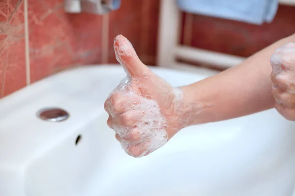Soapy hand giving thumb up