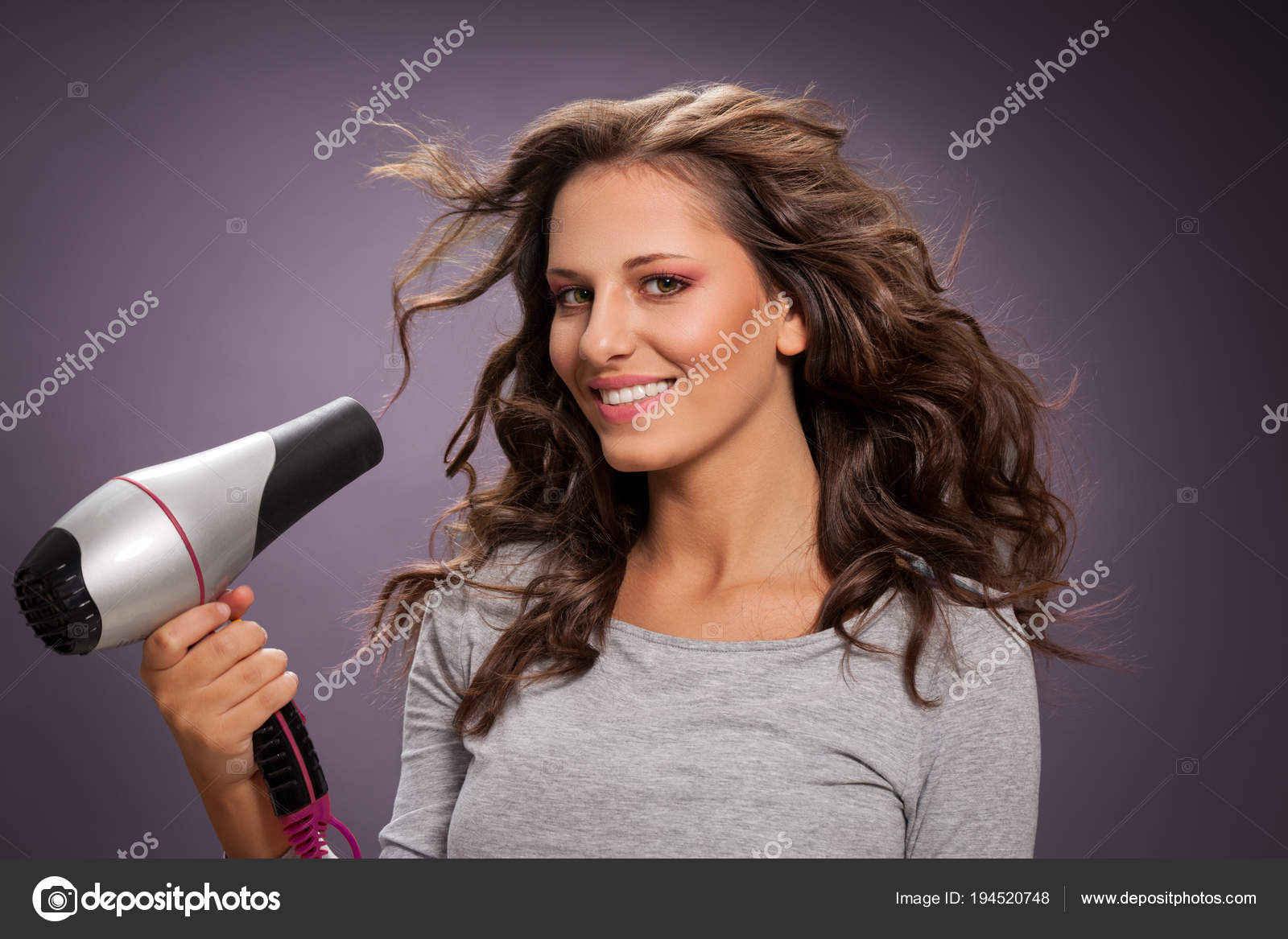 Beautiful Smiling Woman Blow Drying Her Hair Stock Photo