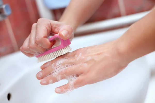 Kvinnliga soapy händer med rengöringsborste — Stockfoto