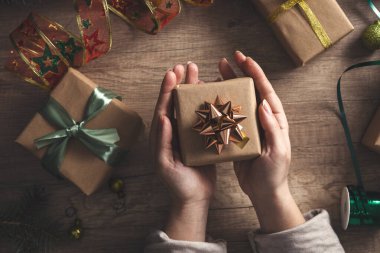 Noel hediyesini tutan eli kesilmiş bir kadın.