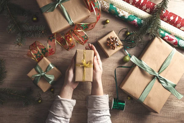 Frauenhände schenken verpackte Weihnachten — Stockfoto