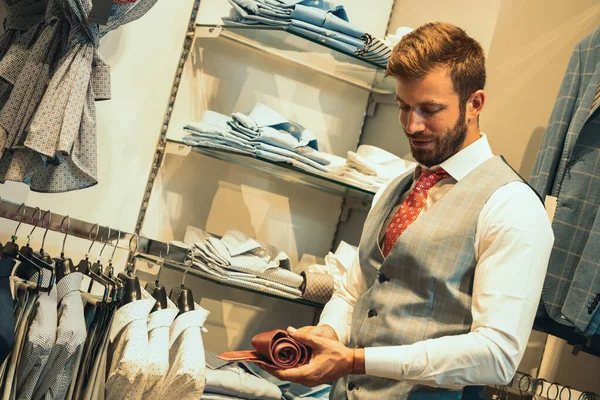 Бизнесмен просматривает галстуки в мужском магазине — стоковое фото