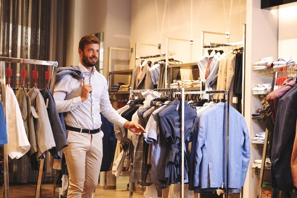 Smiling handsome man buying clothes